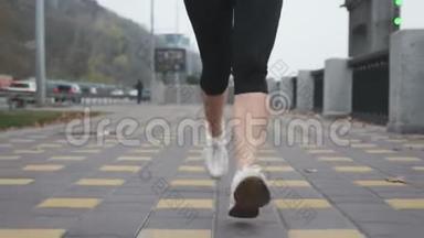 年轻女子`脚穿着白色的专业<strong>跑鞋</strong>，在沿河的城市码头上进行激烈的训练。 运动女运动员