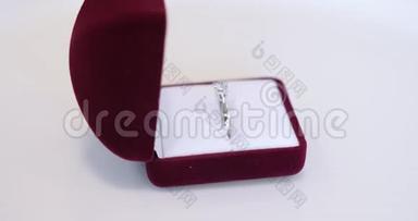 旋转新的白金白金婚礼新娘戒指在精致的现代红色盒子白色背景特写