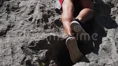 夏天攀岩。 登山者的腿很难向上移动到顶端。