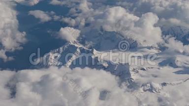 从高山上的飞机俯瞰，大雪纷飞，云中的大冰川