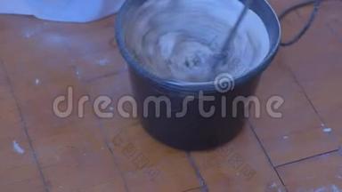 搅拌机搅拌水泥灰泥在桶内使用电动搅拌机，特写视图..