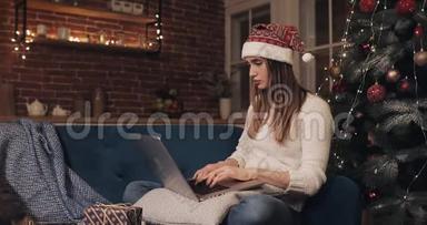 漂亮的白种人女孩坐在圣诞树附近，用她的笔记本电脑思考看屏幕秩序呈现