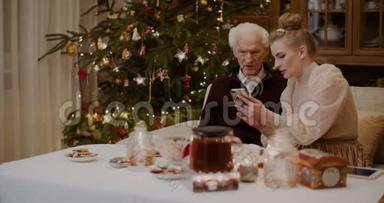 在圣诞<strong>节</strong>教祖父使用<strong>手机</strong>的女人