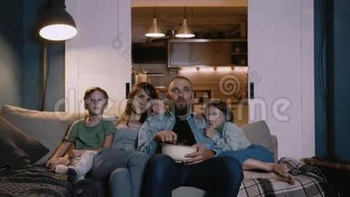 幸福年轻的高加索家庭的时间推移肖像，两个孩子在家里沙发上看电影，一起聊天。