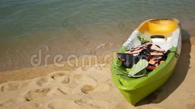 用桨划在沙滩上的皮艇，被蓝色的海水冲刷。 波浪状的水晶水中泛着五颜六色的独木舟，热带寂寞