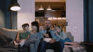 快乐的白人家庭和两个孩子<strong>一起看电影</strong>，在家里<strong>一起</strong>在沙发上聊天。 娱乐概念。