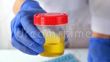 医生或化验员出示带有尿液样本的<strong>容器</strong>，以便在医学<strong>实验</strong>室进行分析和研究