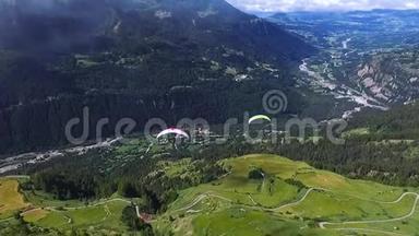 滑翔伞用降落伞在山上的青山和田野上飞行。