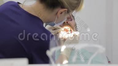 女牙医正在牙科诊所治疗病人。 做牙齿检查。 口腔科医生治疗患牙`龋病