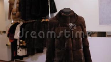 在一家女服装店里，一件漂亮`貂皮大衣在人体模型上。 慢动作。