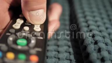 广告或电视频道切换.. 雄手拇指反复按下遥控器上的通道向下按钮，手