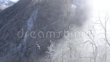 滑雪电梯在低地的雪山森林上移动。 载着滑雪者和滑雪者到雪坡的滑雪缆车