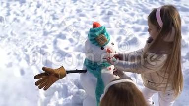 快乐的孩子们在下雪的冬天散步时堆雪人。 主题圣诞假期冬新年.. 冬天快乐