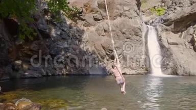 少女少年从<strong>蹦极</strong>跳入山河流淌的瀑布景观.. 少女潜入瀑布