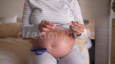孕妇手持<strong>胰岛</strong>素注射器和安瓿<strong>胰岛</strong>素的特写。