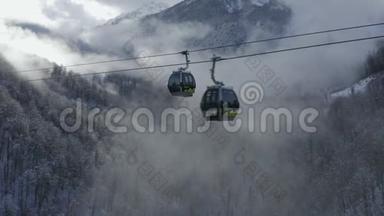 在<strong>冬季度假胜地</strong>的雾状林地上，可以看到滑雪缆车。 在雪间运送运动员的空中景观滑雪电梯