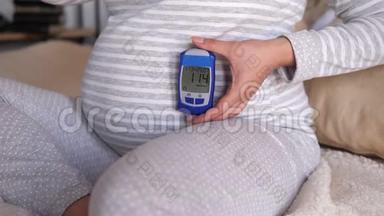 显示<strong>血糖仪</strong>的孕妇，测量<strong>血糖</strong>的结果很高