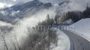 无人机视觉suv汽车在冬季山区蜿蜒的道路上行驶.. 雪山峰和森林上的冬季蛇形道路