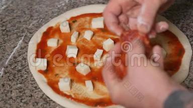 厨师面包师的手，统一添加意大利香肠到比萨饼。 披萨艺术。 披萨的制作过程..