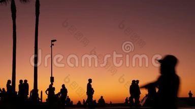 少年跳滑板的剪影骑长板，<strong>夏日夕阳</strong>背景.. 洛斯威尼斯海滨溜冰场