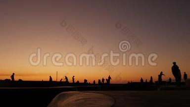 少年跳<strong>滑板</strong>的剪影骑长板，夏日夕阳背景.. 洛斯威尼斯海滨溜冰场