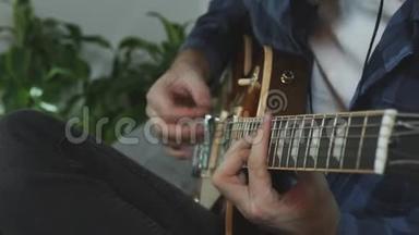 他用电吉他演奏。 双手在吉他上弹奏和弦。 音乐概念
