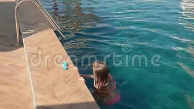 青少年女孩在度假酒店的室外游<strong>泳池</strong>游泳。 小女孩漂浮在<strong>蓝色</strong>的游<strong>泳池里</strong>。 游客