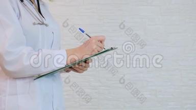 无法辨认的女医生在处方板上书写诊断、病例病史