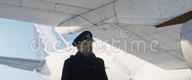 乘坐飞机或飞机机翼下行走的带帽的老年飞行员或飞行员