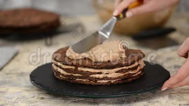 在家做巧克力层的拿破仑蛋糕：把奶油蛋糕放在烘焙的糕点上。