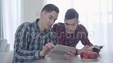 成年白种人在平板电脑上玩电子游戏的<strong>肖像</strong>，并展示给他的孪生兄弟。 布鲁内特<strong>看书</strong>