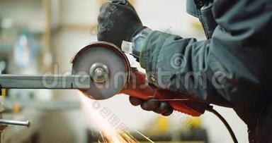 钢铁工业-使用角磨床磨削金属物体的人。