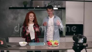 年轻夫妇一起休闲烹饪，在阁楼的灰色厨房里相机录制视频食物博客