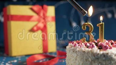 白色<strong>生日</strong>蛋糕31号<strong>金色</strong>蜡烛由打火机点燃，蓝色背景灯和礼品黄色盒子捆绑