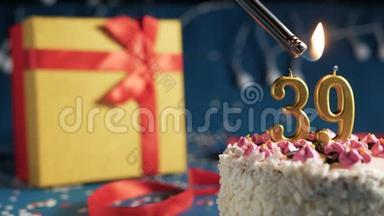 白色生日蛋糕数字39金色蜡烛由<strong>打火</strong>机燃烧，蓝色背景灯和礼品黄色盒子捆绑