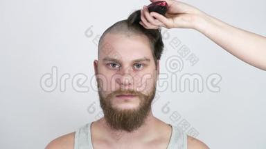 那个留<strong>胡子</strong>的家伙用剪<strong>刀刮胡子</strong>，看着相机。 理发店。