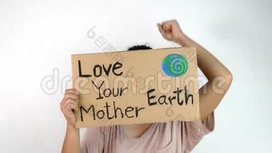 女人抱着`爱你的地球母亲`海报上的演示，由于气候变化的塑料污染。