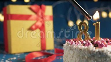 白色生日蛋糕，81号金色蜡烛用打火机点燃，蓝色背景灯和礼品黄色盒子用红色系着