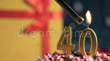 生日蛋糕40支金色蜡烛用打火机点燃，蓝色背景礼品黄色盒子用红色丝带系好