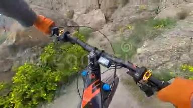 从行动相机，电动自行车车把和手，同时骑在悬崖边缘沿海。 骑自行车的人手牵手