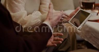 孙女和祖父在家讨论数码平板电脑