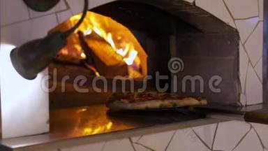 意大利比萨饼意大利辣肠是在烤箱里煮的，餐厅厨师在餐厅用木头烤的烤箱里拿出比萨饼。