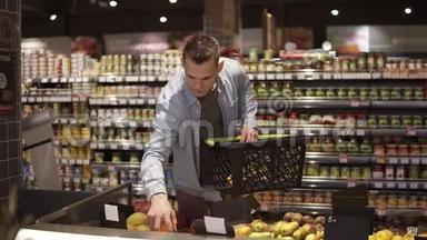一家杂货店超市的农产品部门，年轻、积极的男人在买水果和蔬菜的画像