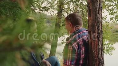 成年夫妇在针叶林的河岸上。 快乐的男人和女人在松林地的河岸上放松。