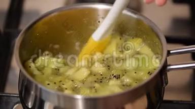女人在平底锅里煮奇异果酱。