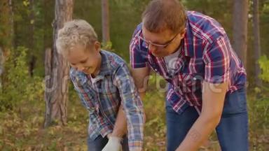 爸爸一起<strong>儿子在</strong>夏天的森林里用斧头砍柴。 <strong>父亲和儿子</strong>用斧头砍木头