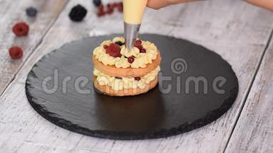 糕点厨师用奶油和浆果制作法国米尔·菲耶。 法式甜点，牛奶酥皮点心和奶油冻