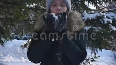 冬天的城市公园里一个可爱的年轻女子的肖像，在<strong>松枝</strong>的背景下颤抖着雪