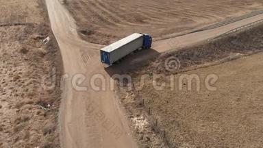一辆大型卡车和一辆拖车沿着土路行驶，在附近寻找掉头的地方