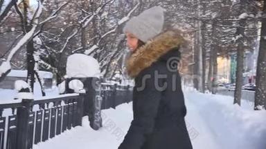 年轻漂亮的<strong>女人</strong>穿着热情的衣服在一个城市街道的背景下，冬季日落。 慢动作